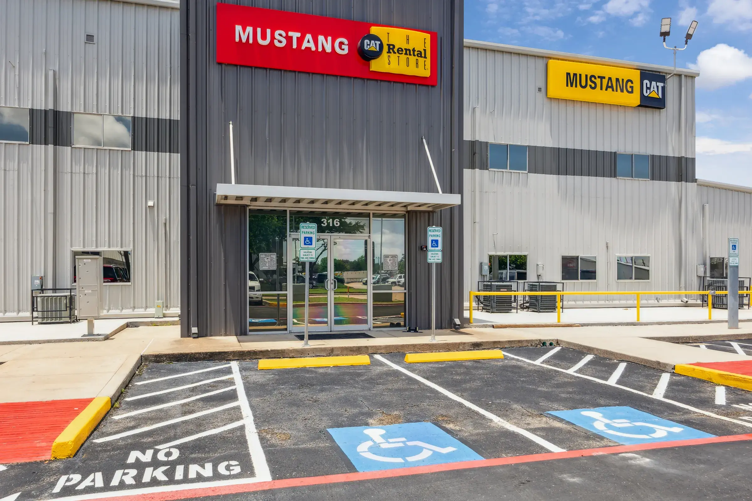 The customer entrance under the Mustang CAT and Cat Rental signs, with marked accessible parking out front
