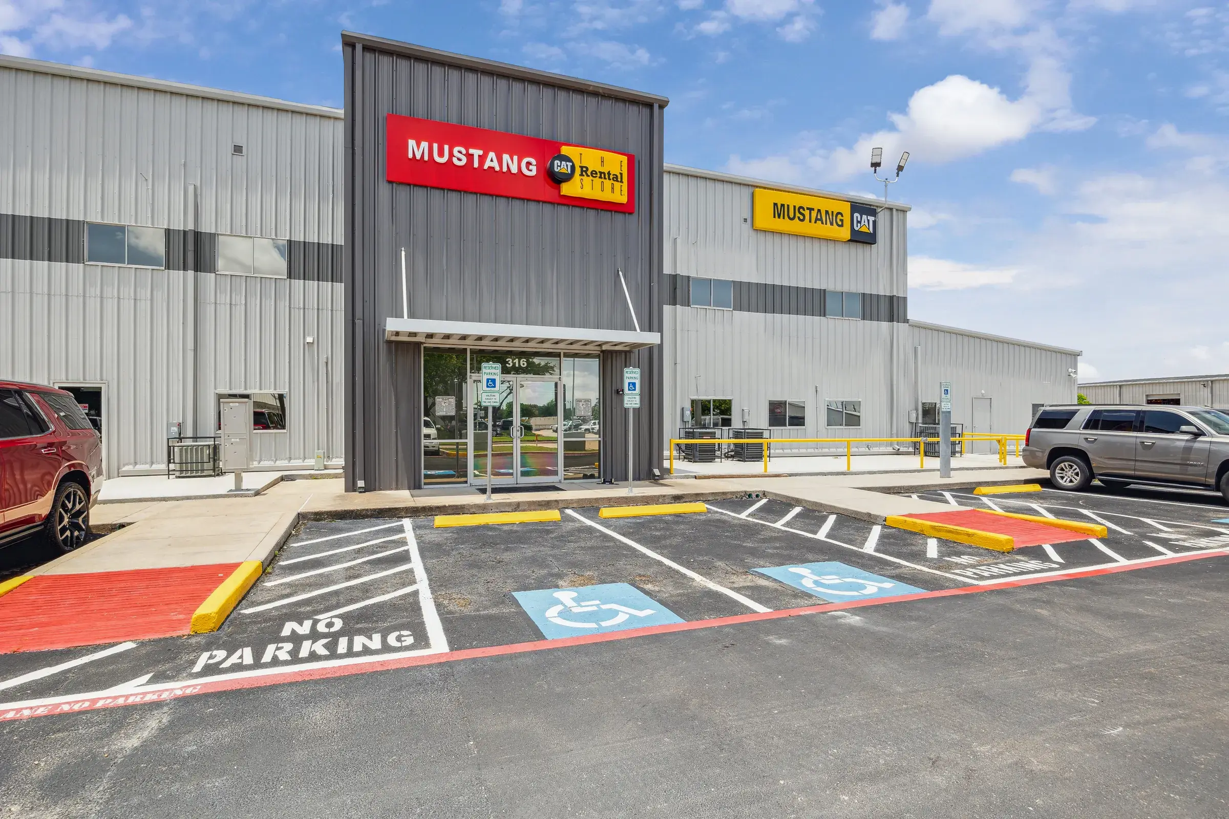 The branded entry canopy seen straight on from across the customer lot