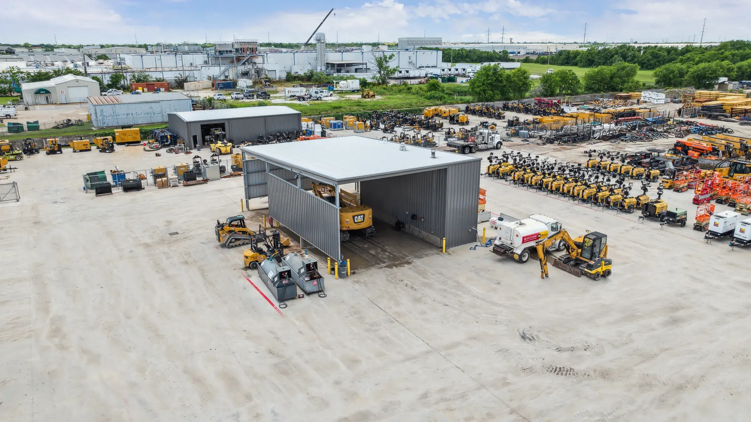 Aerial of the covered canopy structure with equipment staged in rows beside it