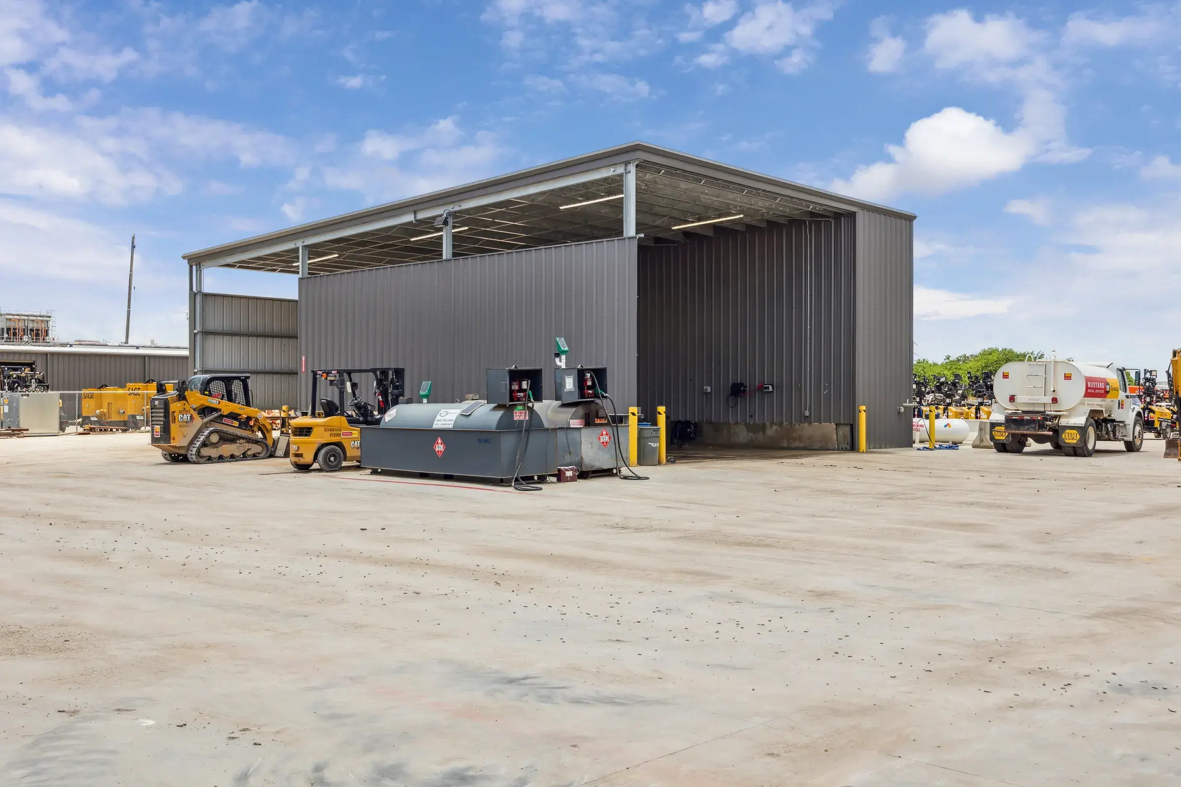The covered canopy structure over the yard with machines parked underneath