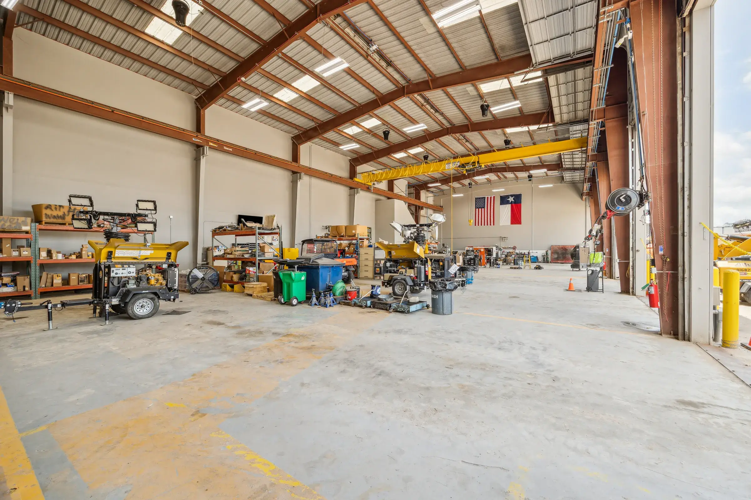 The shop under its yellow crane rail, tooling and carts staged along the wall