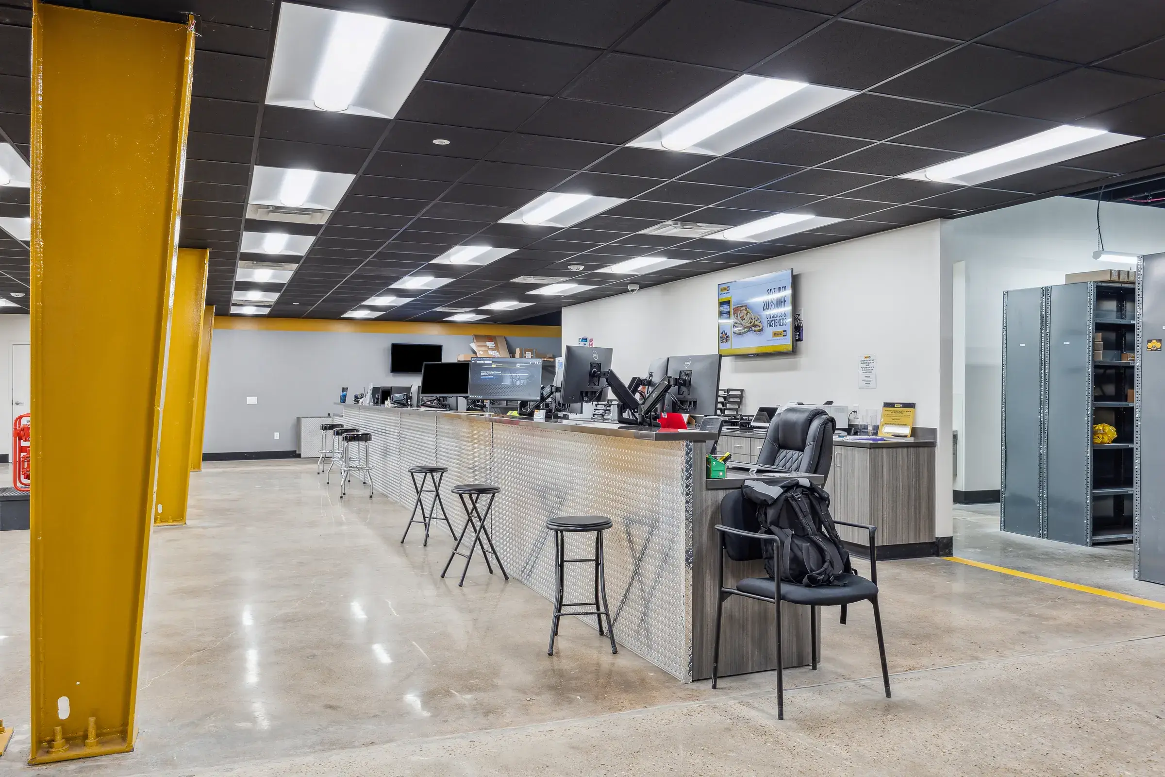 The service counter under the yellow column, stools pulled up along the front