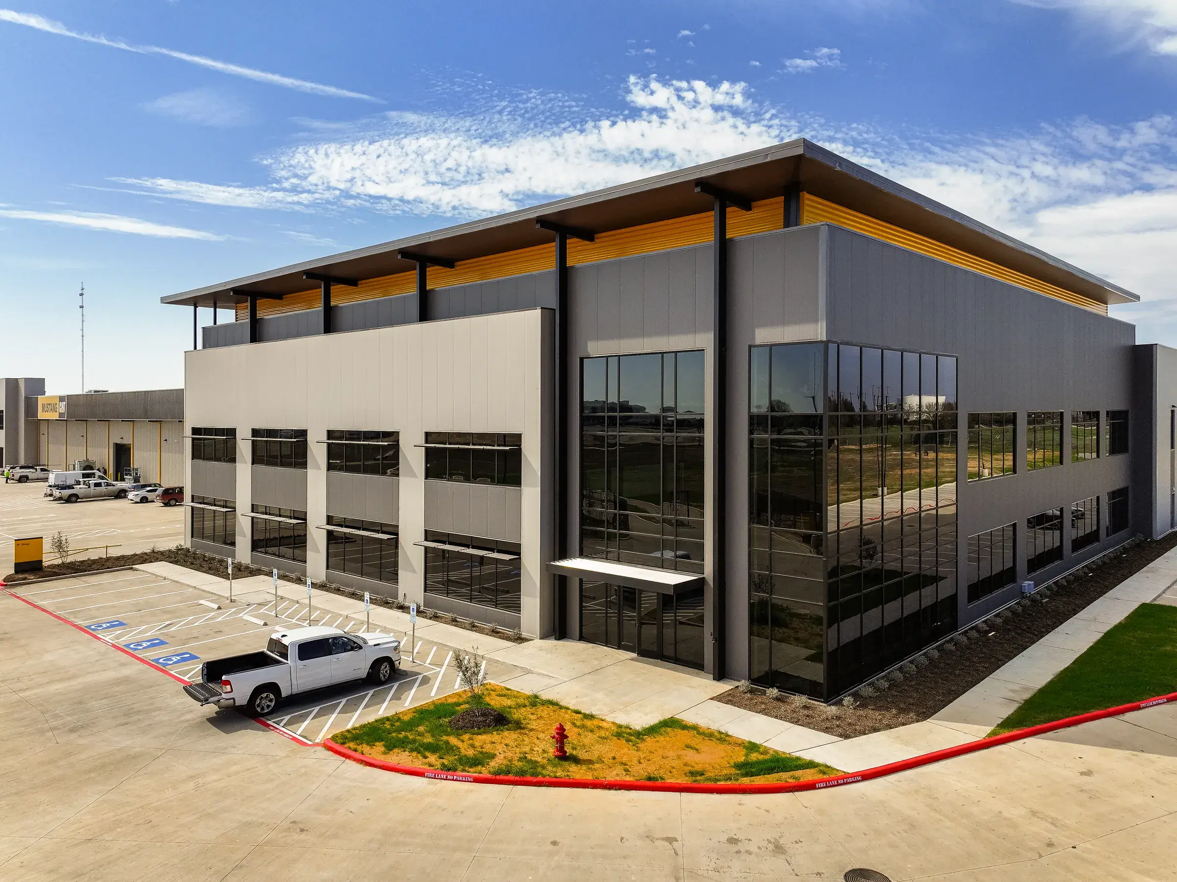 The two-story administrative block at the corner of the facility — dark glass under a deep metal canopy
