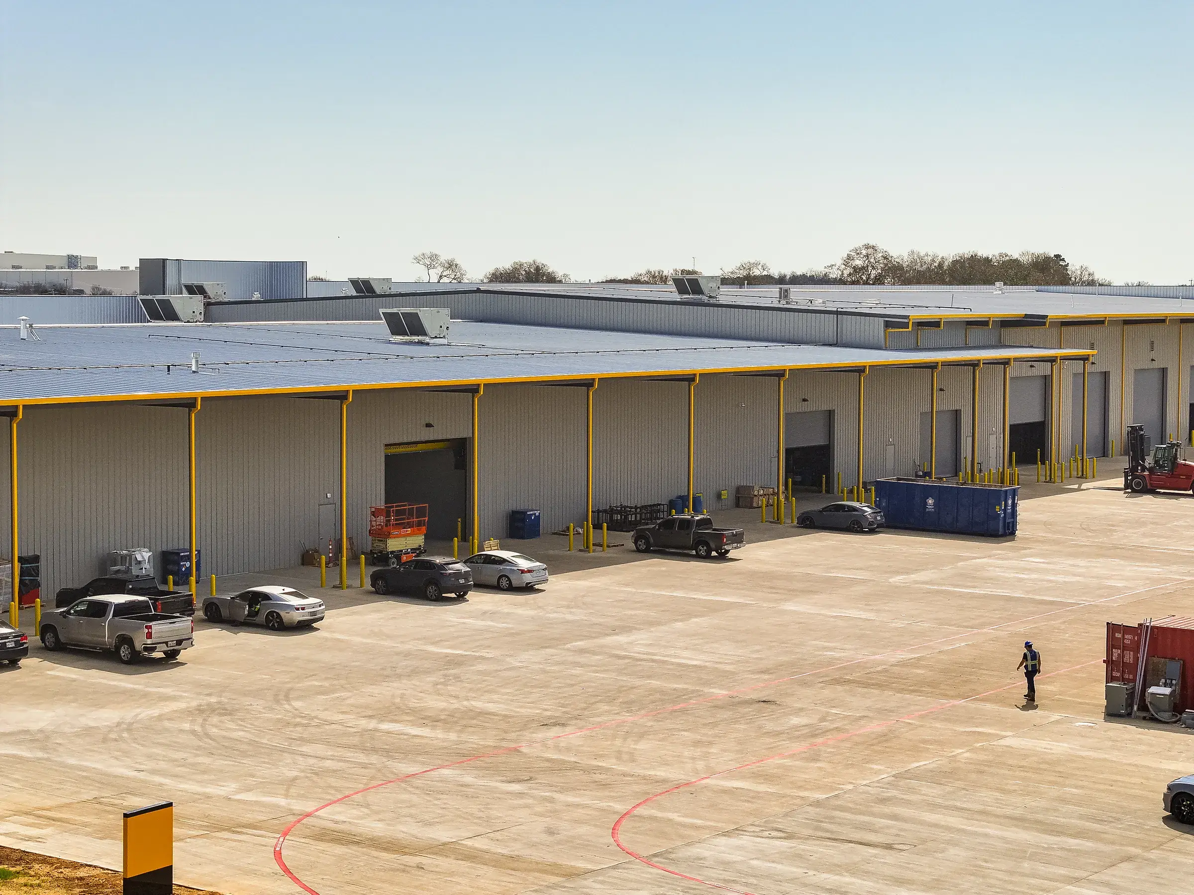 The service apron in use — containers, trucks, and crews working along the bay doors