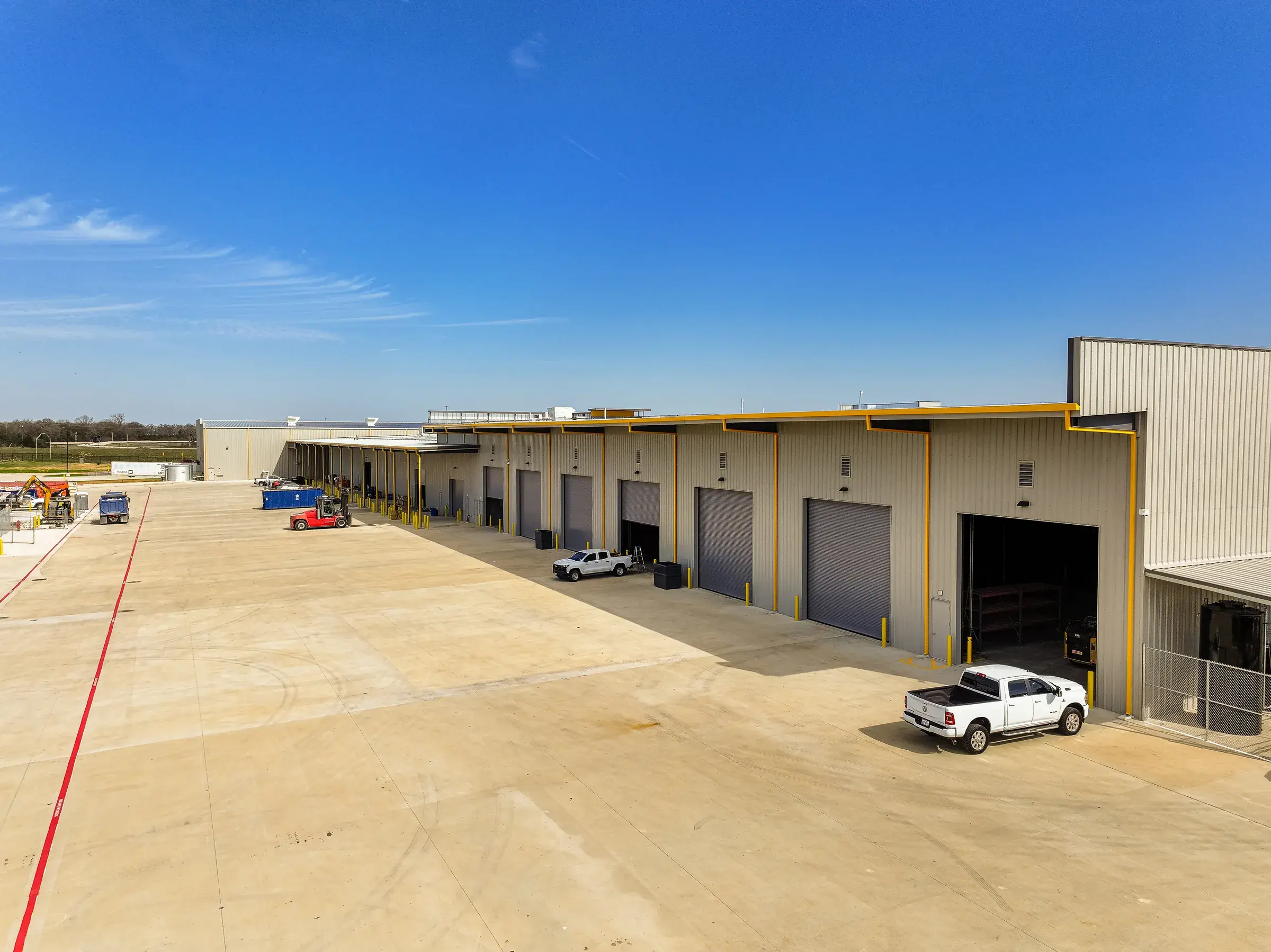 A run of overhead doors down the shop elevation with a truck pulled up outside