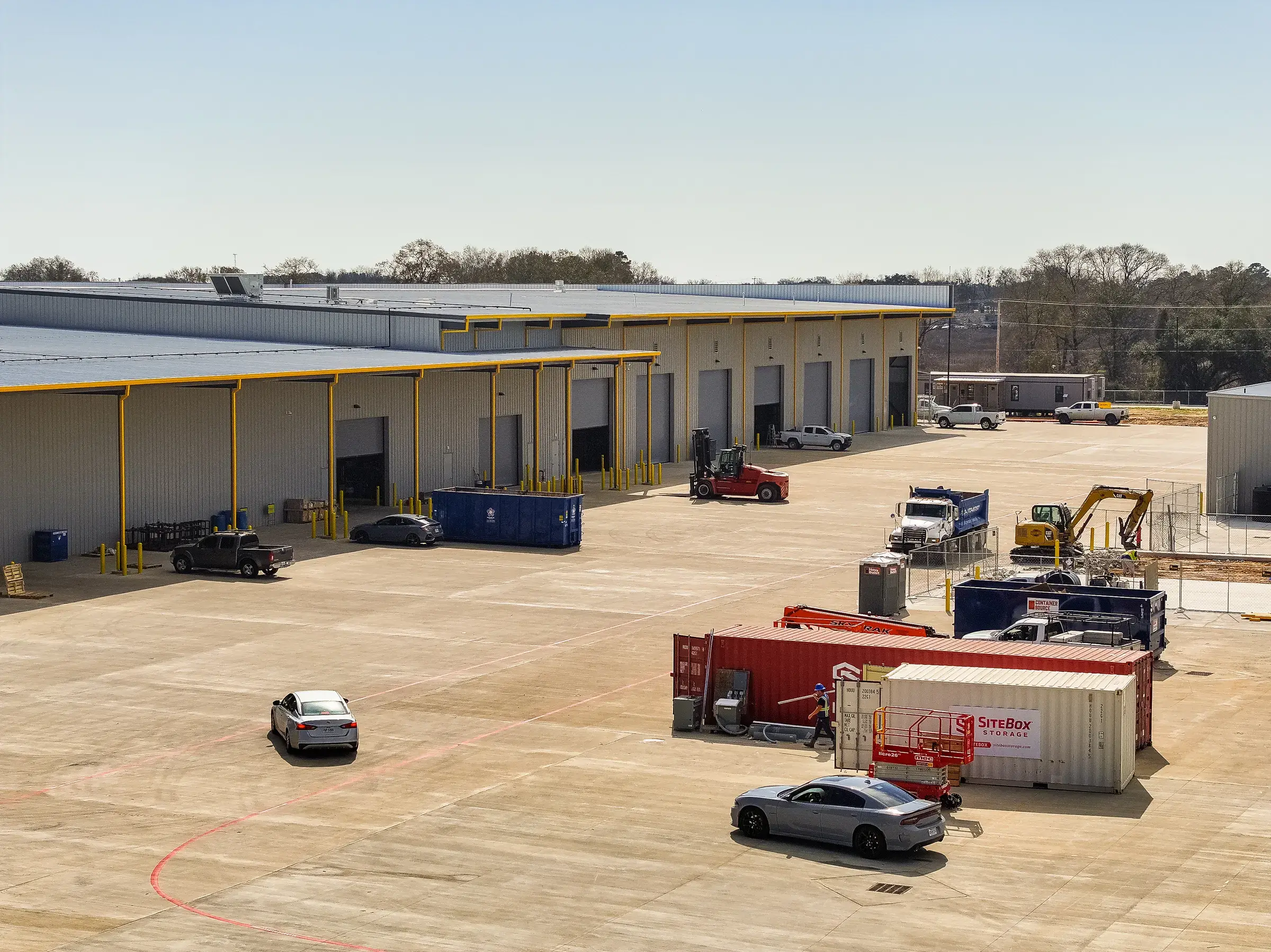 Containers and equipment lined up along the back of the yard