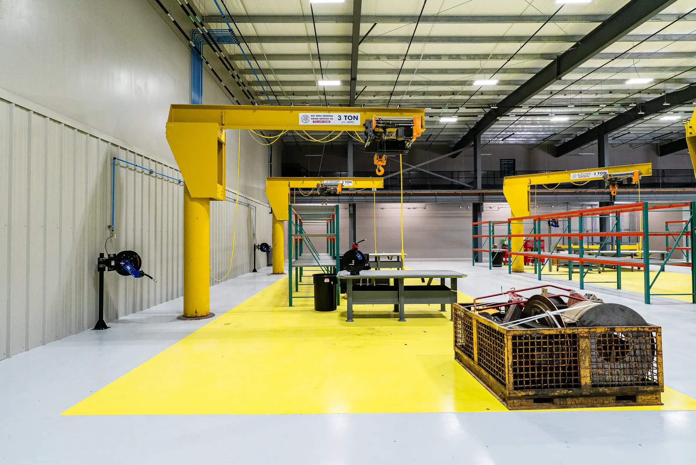 A jib crane close up on its column, the yellow work zone laid out beneath it
