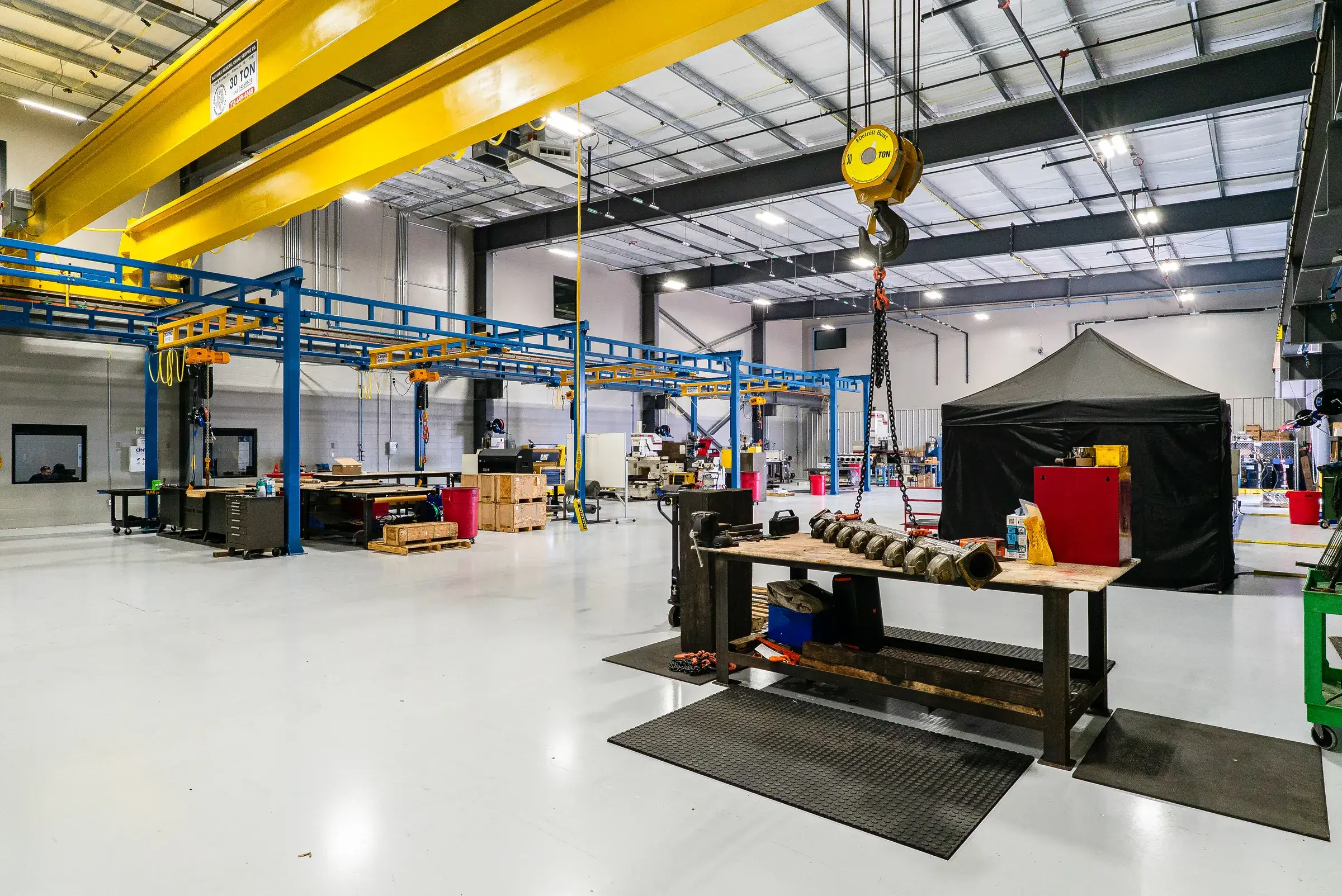 A component repair bay with workbench, tooling, and a work tent set up on the floor