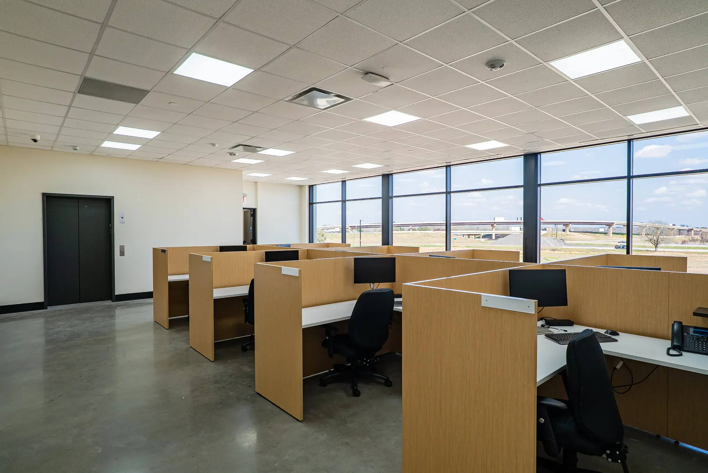 The administrative office — workstations along a window wall looking out over the site