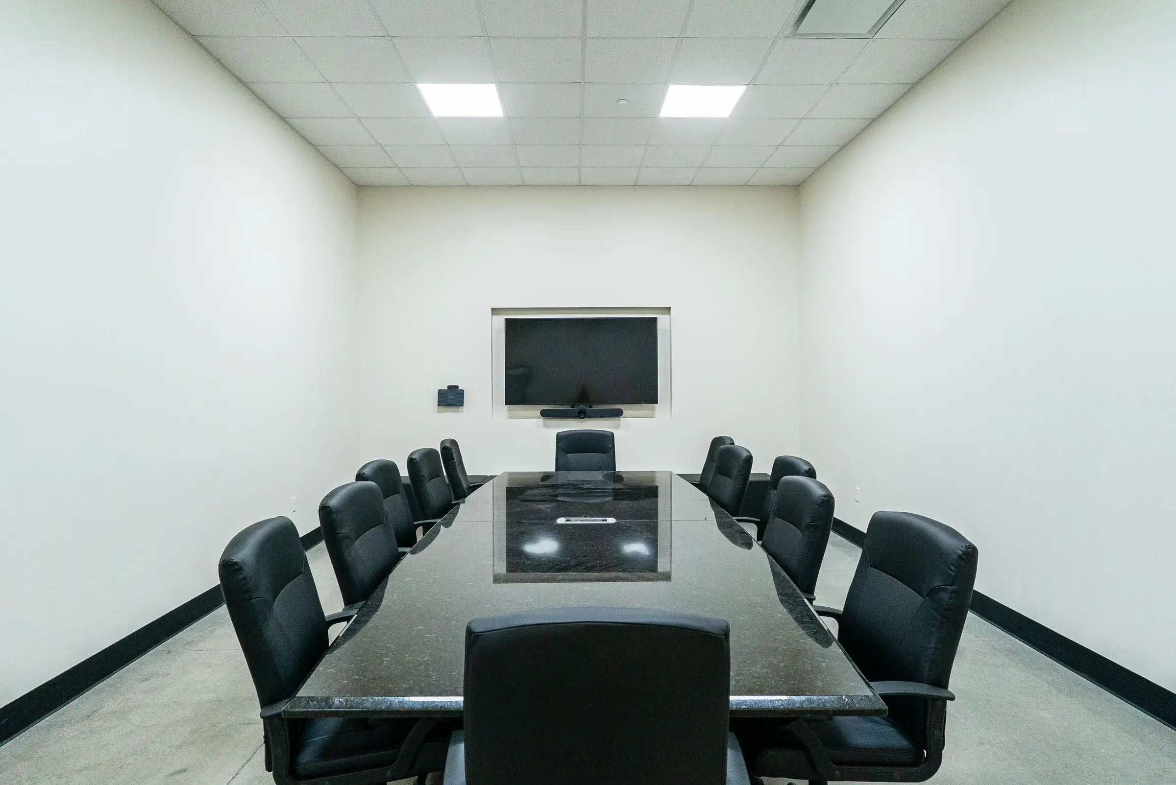 The conference room with its display screen at the head of the table