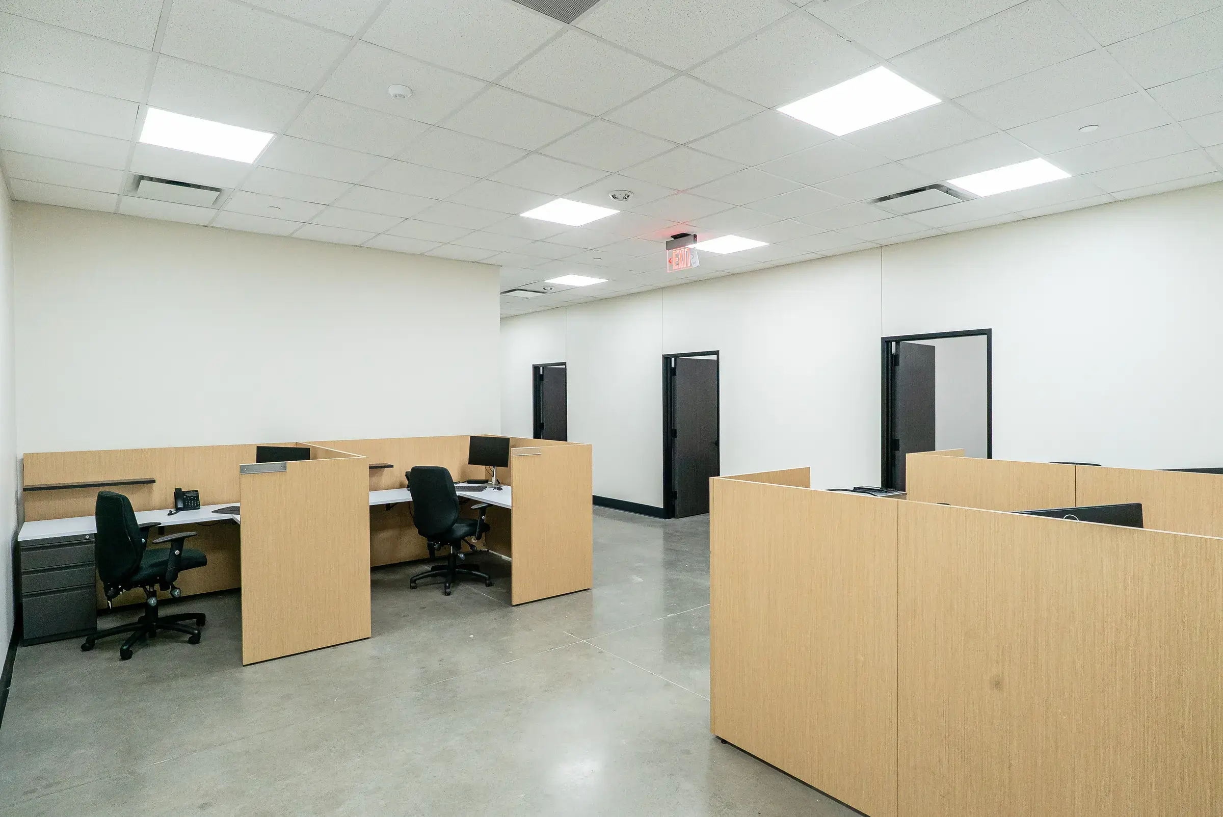 Open workstations on the office floor, daylight from the window wall behind