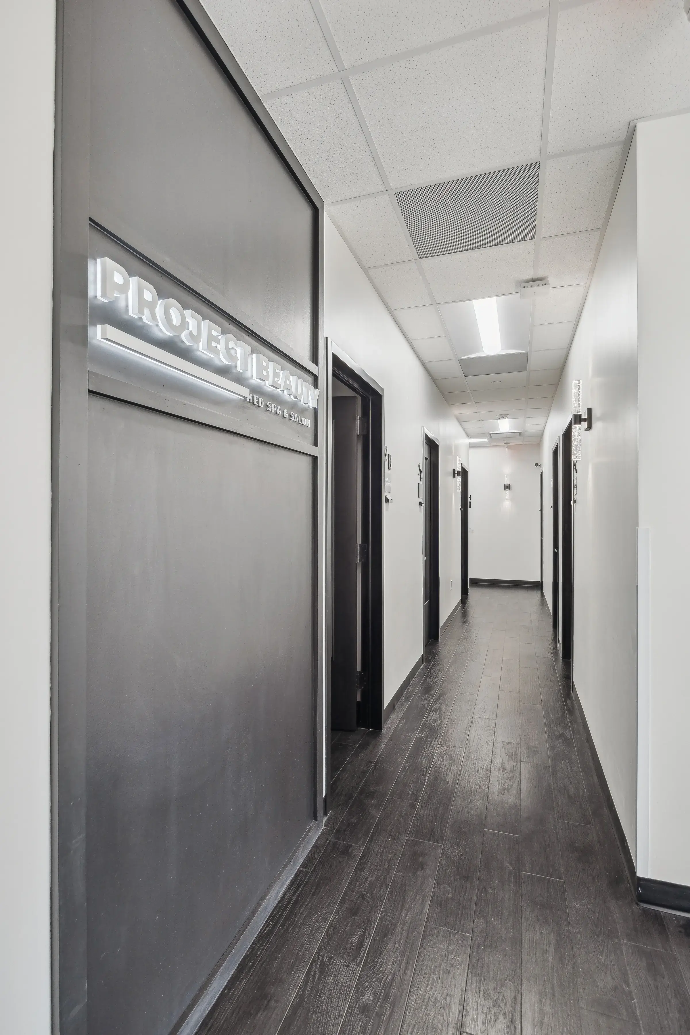 The corridor to the rental suites with the backlit Project Beauty sign
