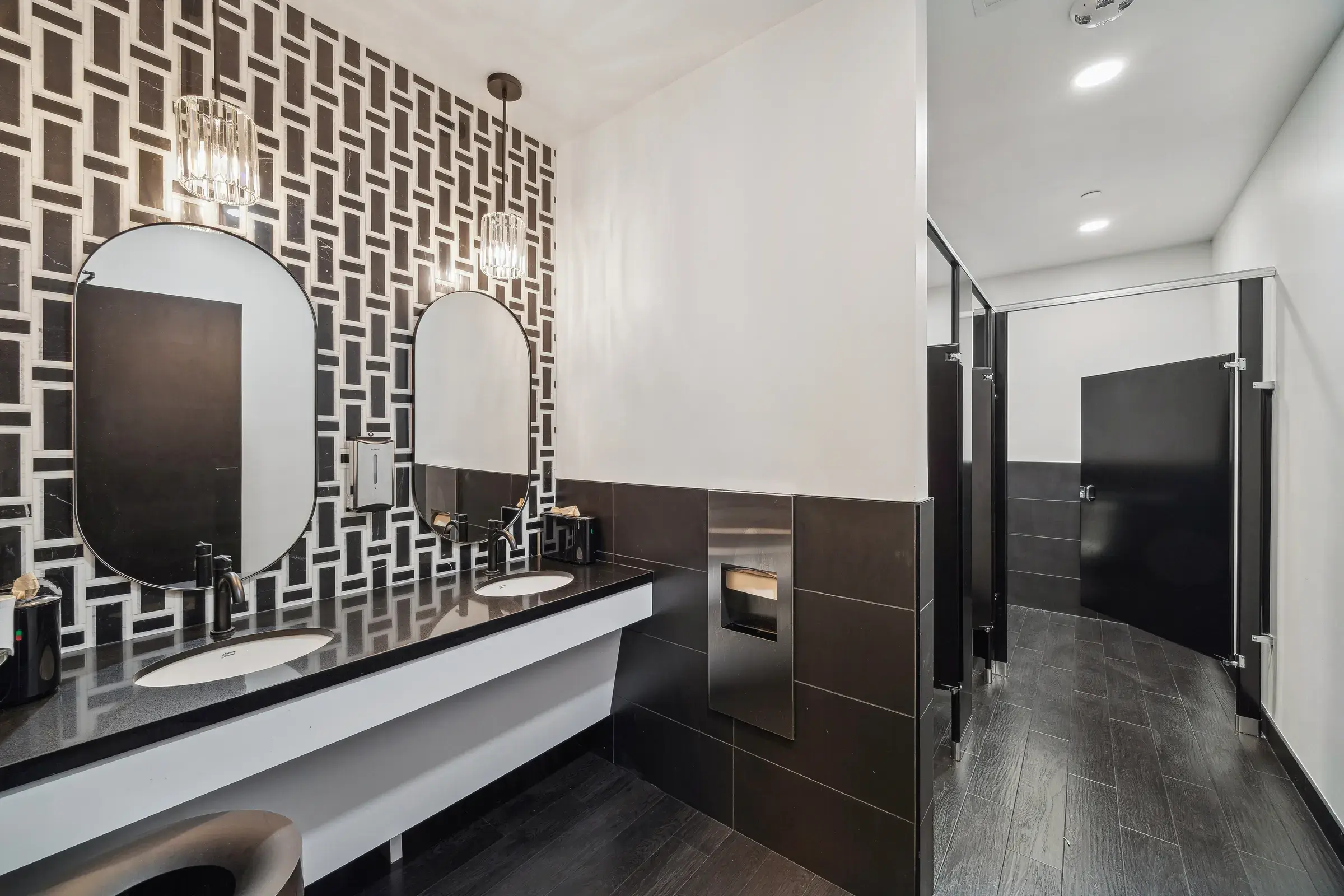 The restroom with a patterned feature wall behind a double vanity