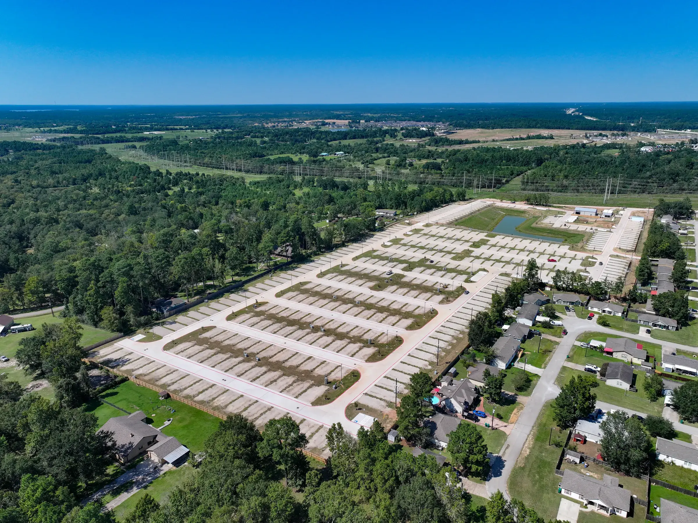 Oblique aerial of the site alongside the neighboring streets, showing how the development sits in the surrounding community